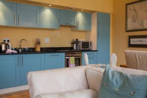 a living room with blue cabinets and a white couch at The Livingstone Loch Ness OS9 in Fort Augustus