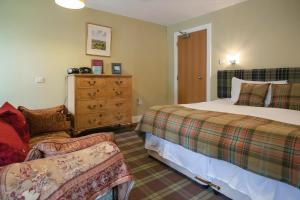 a bedroom with two beds and a dresser and a couch at The Livingstone Loch Ness OS9 in Fort Augustus