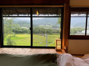 a bedroom with a large window with a view of a field at Osugi-ya 大杉屋 in Wazuka