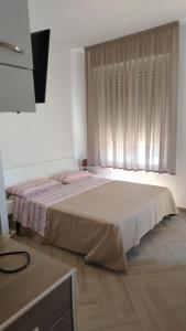 a bedroom with a large bed with a window at Casa Vacanze Giada in Reggio Calabria