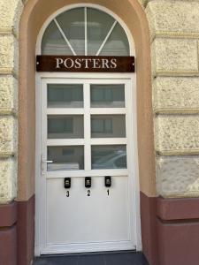 a white garage door with the words postsers on it at PostersApt3-Cozy Cinema Vibes in Vienna
