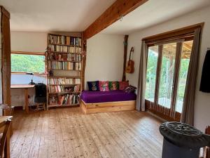 un soggiorno con divano viola e libreria di Small house, charming cabin, Cozy place a Montbrun-Bocage