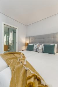 Un dormitorio blanco con una gran cama blanca. en Urban Oasis Six Suites Apts Porto, en Oporto