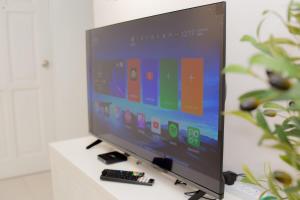ein Flachbildfernseher mit Fernbedienung auf einem Tisch in der Unterkunft 5min walk to Tebrau ÆON Mall 1-5pax Free Netflix in Johor Bahru