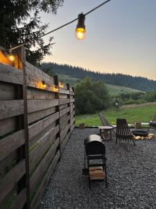 a backyard with a fence and a table and chairs at Stryh xata - Будиночок в Карпатах з чаном-джакузі in Volosyanka