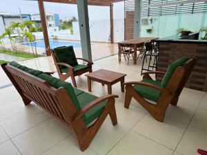 patio con sedie, tavolo e piscina di Excelente casa de praia em Paripueira 5 min do mar a Paripueira