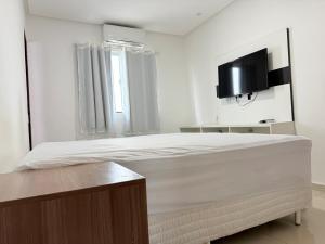 una camera da letto con un letto e una TV a parete di Excelente casa de praia em Paripueira 5 min do mar a Paripueira
