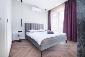 a bedroom with a large bed and a large window at Sodų Vilos in Kaunas