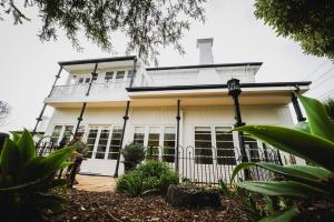 a white house with a balcony on top of it at Annesley House in Portland