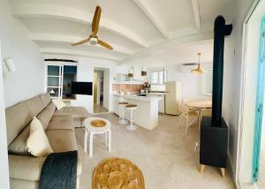 a white living room with a couch and a kitchen at Cala Vemar - 2 Mediterranean Beach Houses in Haza del Trigo