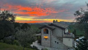 a building with a sunset in the background at Farm Ca Nick in Fermo +46 photos