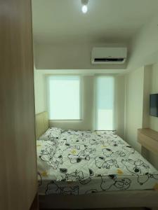 ein Schlafzimmer mit einem Bett und einem Fenster in der Unterkunft Luxury Stay Osaka Riverview Apartemen Pik 2 in Rawalumpang