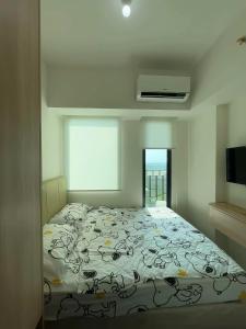 ein Schlafzimmer mit einem Bett und einem Fenster in der Unterkunft Luxury Stay Osaka Riverview Apartemen Pik 2 in Rawalumpang