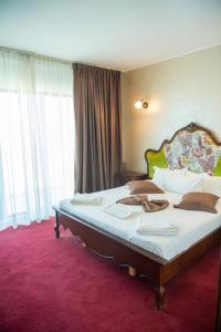 a bedroom with a large bed with a red carpet at MIRA RESIDENCE Apart & Penthouse in Mamaia Nord +82 photos