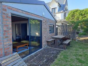 eine Terrasse mit einem Picknicktisch und einer Bank in der Unterkunft Tokkelos - Beach front Bungalow in Witsand + 9 Fotos