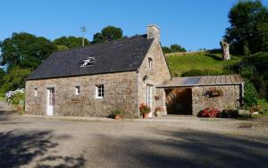 a small stone building with a black roof at Gîte Ar Boutilh in Ploulech