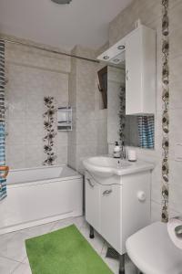 a bathroom with a sink and a tub and a toilet at Konstanzer Podu Ros 2 - 3 camere, bucatarie, aer conditionat, masina de spalat in Iaşi