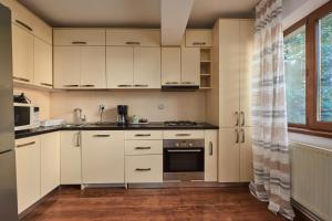 a kitchen with white cabinets and a window at Konstanzer Podu Ros 2 - 3 camere, bucatarie, aer conditionat, masina de spalat in Iaşi +7 photos