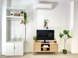 un salon avec une télévision sur une table en bois dans l'établissement Designer studio 5 min from train Station María Zambrano and 15 min from beach, à Malaga