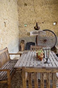 a wooden table and bench in a room with a wheel at Pure Gardères in Monlezun