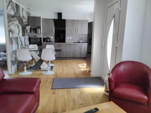 Una sala de estar con un sofá rojo y una cocina. en La maison des magnolias, en Pommerit-le-Vicomte 10 fotos más