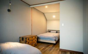 ein Schlafzimmer mit 2 Betten und einer Kommode darin in der Unterkunft Retaruke-レタルケ- in Biei
