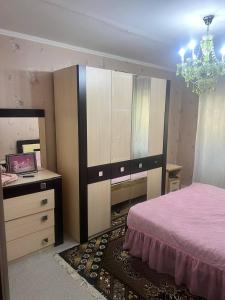 a bedroom with a bed and a dresser and a mirror at Karakol City Center in Karakol