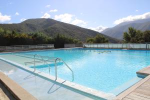 a large swimming pool with mountains in the background at Domaine du Pas du Ventoux Hameau de la Garrigue in Mollans-sur-Ouvèze
