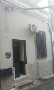 a white building with a door and a fan at MaGa House in Catania