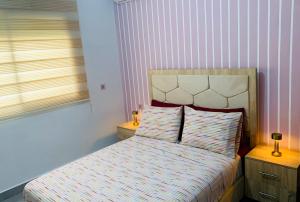 a small bedroom with a bed with two pillows at Appart Cosy Résidence Perla in Saïdia +6 photos