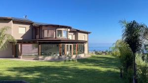 ein Haus mit einem großen Hof mit einer Palme in der Unterkunft Altum Hotel Tropea in Ricadi
