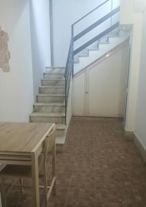 a room with stairs and a wooden table and a staircase at MaGa House in Catania +14 photos