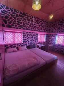 a purple bedroom with a bed with purple lights at PINK HOUSE DORMENTRY Vattakanal in Kodaikānāl