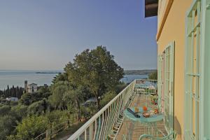 a balcony with a table and a view of the water at La Casa degli Artisti in Gardone Riviera