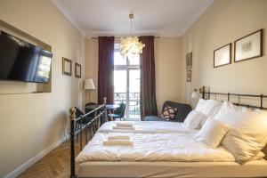 a bedroom with a large bed and a window at Plac Matejki Apartments by Noah in Kraków