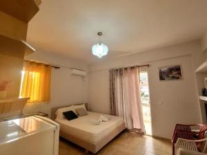 a small bedroom with a bed and a window at Saranda Promenade Studio Apartment in Sarandë