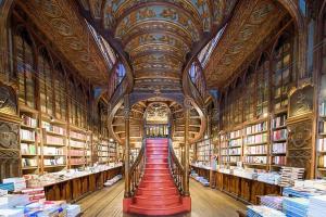 Una gran biblioteca con muchos libros y una escalera. en Apartamento T3 perto do Centro do Porto, Check-in 24 horas,Cozinha totalmente equipada, Wi-Fi 44Mbps, Propriedade Confortável e Espaçosa, Com Vaga de Carro Pública, Adequada para famílias, hóspedes em negócios e grupos de amigos e nomades digitais, en Oporto