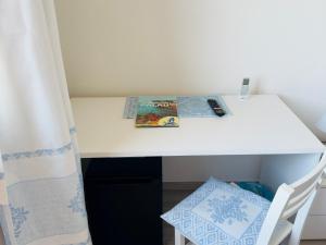 a white desk in a small room with a chair at Blumarine in Palau