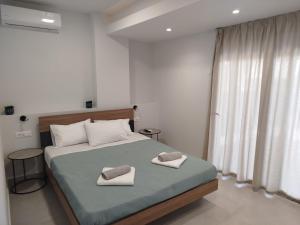 Un dormitorio con una cama con dos toallas encima. en MC Luxury Living, en La Canea