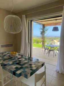 a dining room with a table and a view of a patio at Villa Heron Sicily in Noto