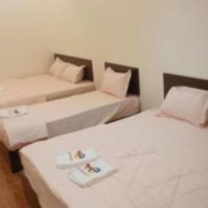 a room with two beds and a couch at mulia homestay in Teluk Intan