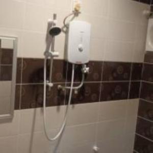 een douche in de badkamer met een föhn bij mulia homestay in Teluk Intan