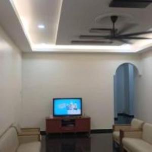 a living room with a ceiling fan and a tv at mulia homestay in Teluk Intan