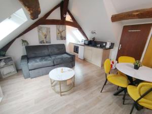 a living room with a couch and a table and chairs at Orléans centre T2 théâtre et cathédrale in Orléans