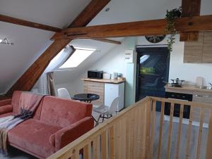a living room with a red couch and a kitchen at Cozy Loft in Hazebrouck +16 photos