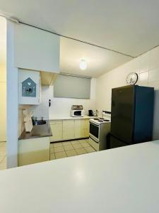 a kitchen with a black refrigerator and a stove at Coastal Bliss Retreat Peacehaven - Pool and Braai - 2 Adults 2 Children in Scottburgh +18 photos