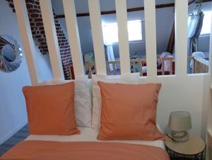 a room with a bed with orange pillows at Cozy Loft in Hazebrouck