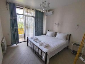 Un dormitorio con una cama con sábanas blancas y una ventana. en Home Shekvetili House, en Shekhvetili
