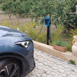 Un coche eléctrico está enchufado a un cargador eléctrico. en Amarena Garden House, en Matera