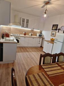 a kitchen with white cabinets and a wooden floor at Orlik in Spišské Bystré +13 photos